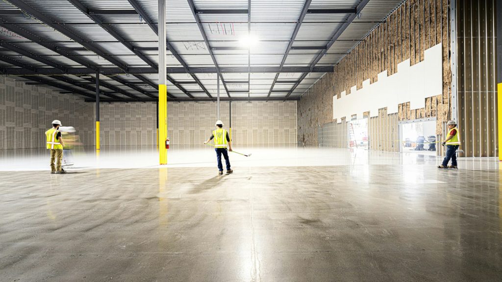 Crew walking a newly finished, empty warehouse