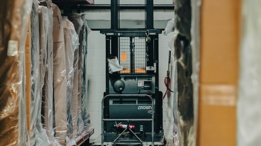 Forklift in a warehouse aisle lined with inventory
