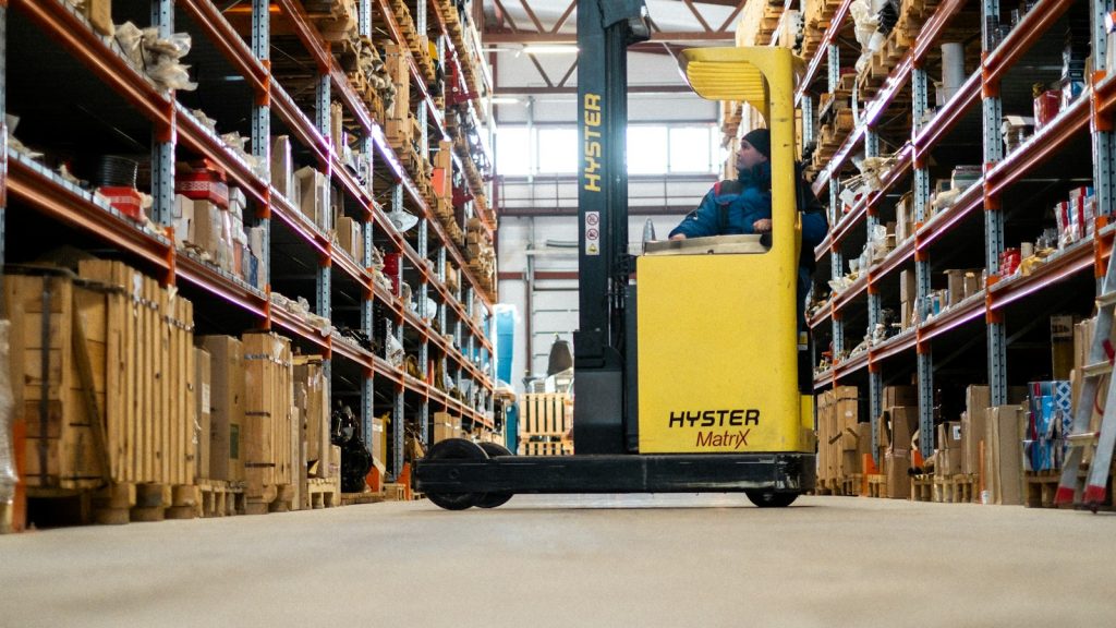 Warehouse worker reaching a package on a high shelf
