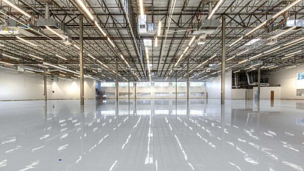 Clean, reflective concrete warehouse floor under high-bay lights